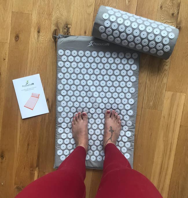 a reviewer standing on the acupressure mat and in gray 