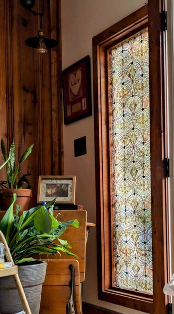 Decorative solid  doorway  with intricate patterns adjacent  to potted plants wrong  a cozy country   with woody  walls