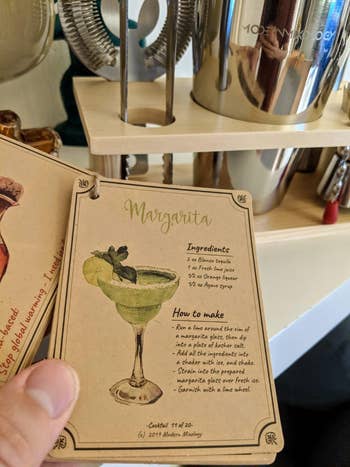 Reviewer holding the recipe booklet, flipped to the margarita recipe card