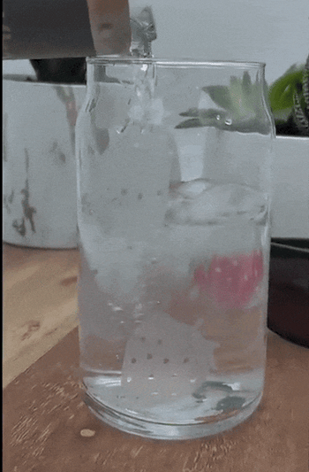 Model pouring water into the cup to show strawberries changing color in real time 