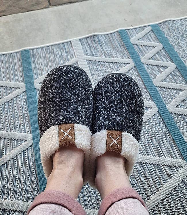 close up of the black and white slippers on a reviewer's feet