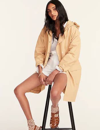 a model in a pale yellow rain jacket