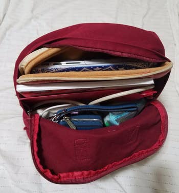 a look inside the canvas backpack and everything it's holding, including a laptop, wallet, and book