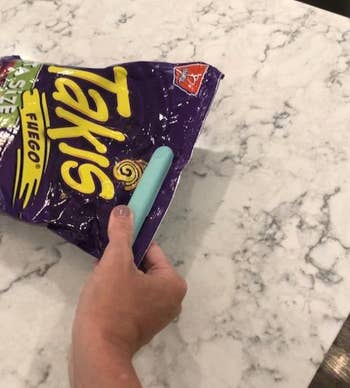 reviewer using the sealer to close a bag of takis