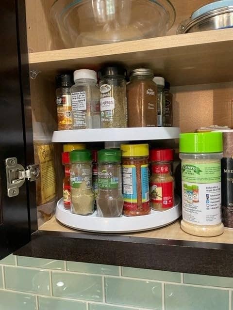 reviewer's kitchen cabinet with spices and small bottles on two tier turntable