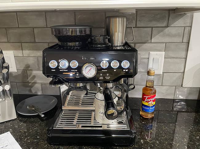 reviewer photo of the espresso machine in black on their kitchen counter