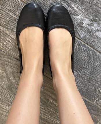 Pair of elemental ballet flats worn connected a tiled floor. Perfect for mundane comfortableness and style