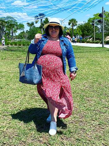 Reviewer wearing the red floral print dress with a denim jacket