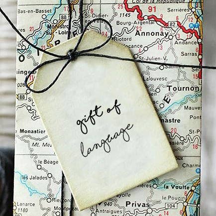 A package wrapped with wrapping paper that looks like a map, with a note reading 