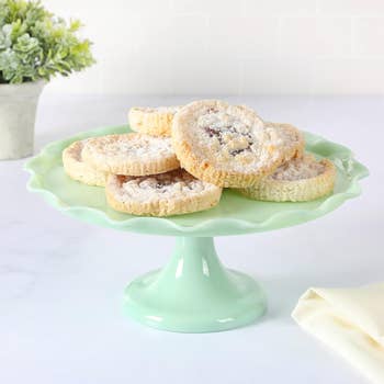 A green cake stand displaying a selection of cookies