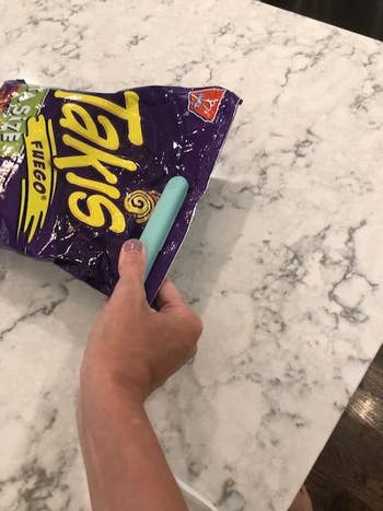 another reviewer using the tool to seal a bag of takis
