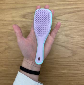 Reviewer holding mini tangle teezer