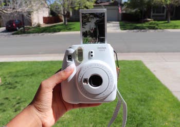 reviewer holding camera with photo coming out of top