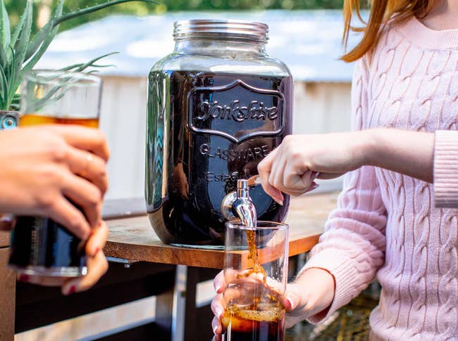 model pouring cold brew from the mason jar into glass