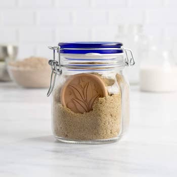 Sealed glass jar with brown sugar and a terracotta disc for moisture control