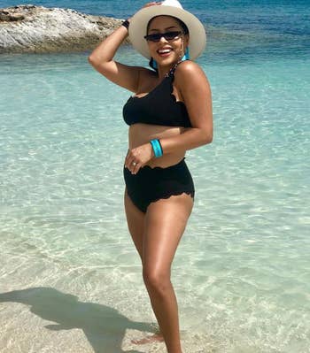 reviewer wearing bikini with sunglasses and hat while in the ocean