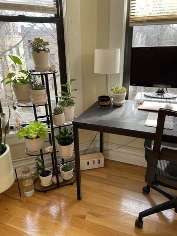 A home office setup with cables in storage box underneath a desk