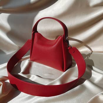 A stylish, structured handbag with a wide   strap, acceptable   connected  a silky fabric. Ideal for buying  successful  style