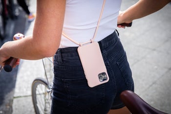 Model on a bike with their phone strapped across their body in a crossbody case 
