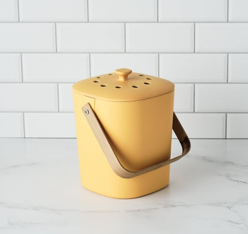 the compost bin in yellow sitting on a countertop 