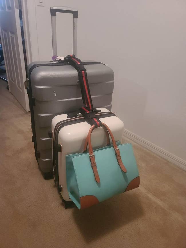 Three stacked pieces of luggage held together by luggage strap