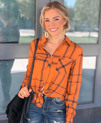 same reviewer wearing the orange plaid button-down tied in a knot