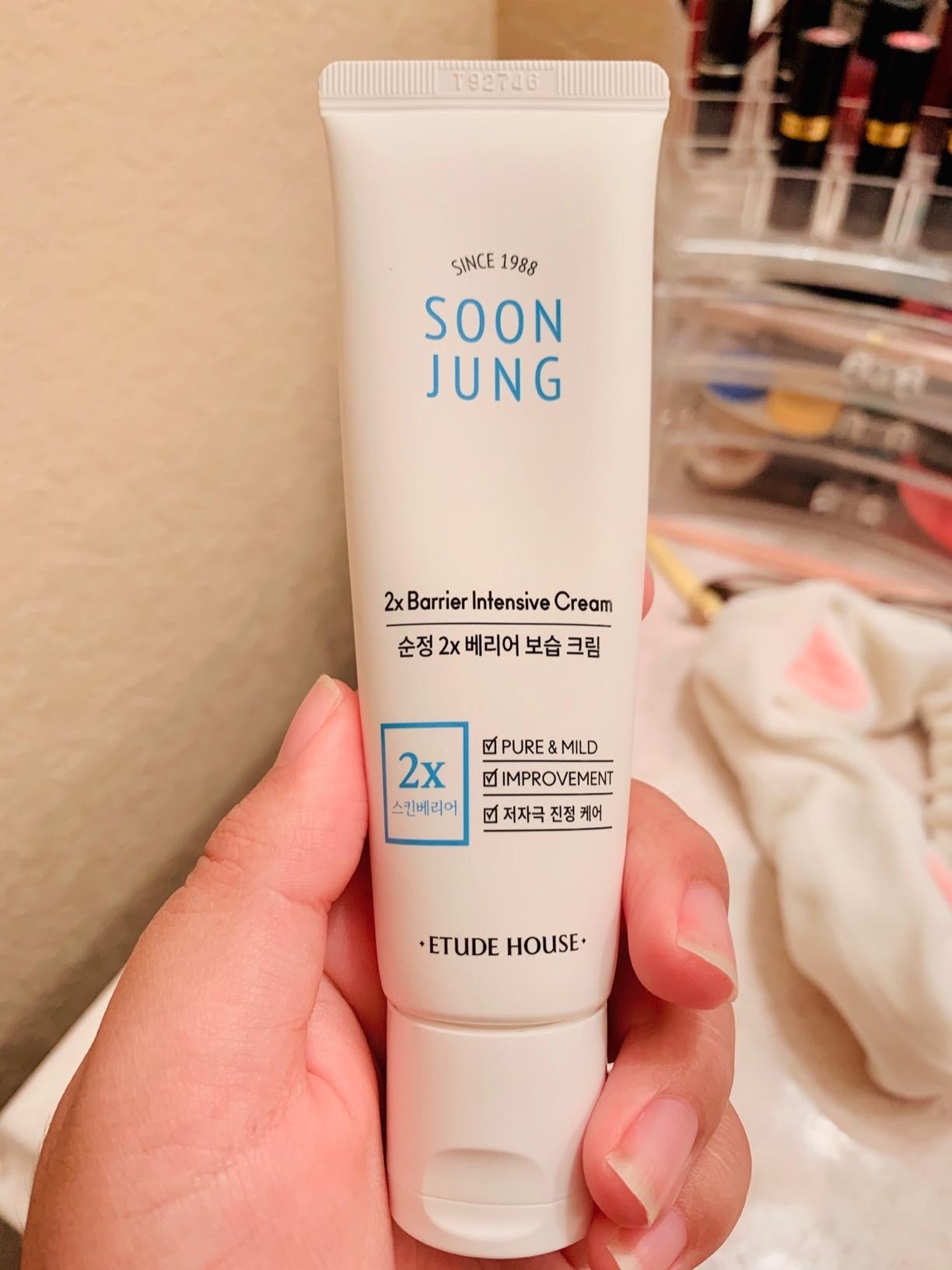 the reviewer holding a tube of the hydrating facial cream
