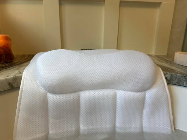 Ergonomic achromatic  representation  foam pillow connected  a marble surface, showcasing its contoured plan  for cervix  support