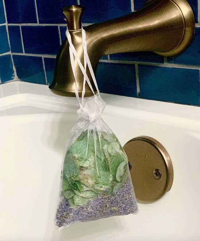 eucalyptus and lavender shower pouch hanging in a bath tub