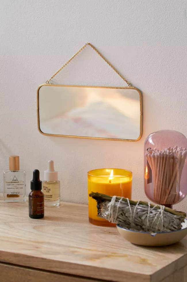 small mirror on wall above a shelf