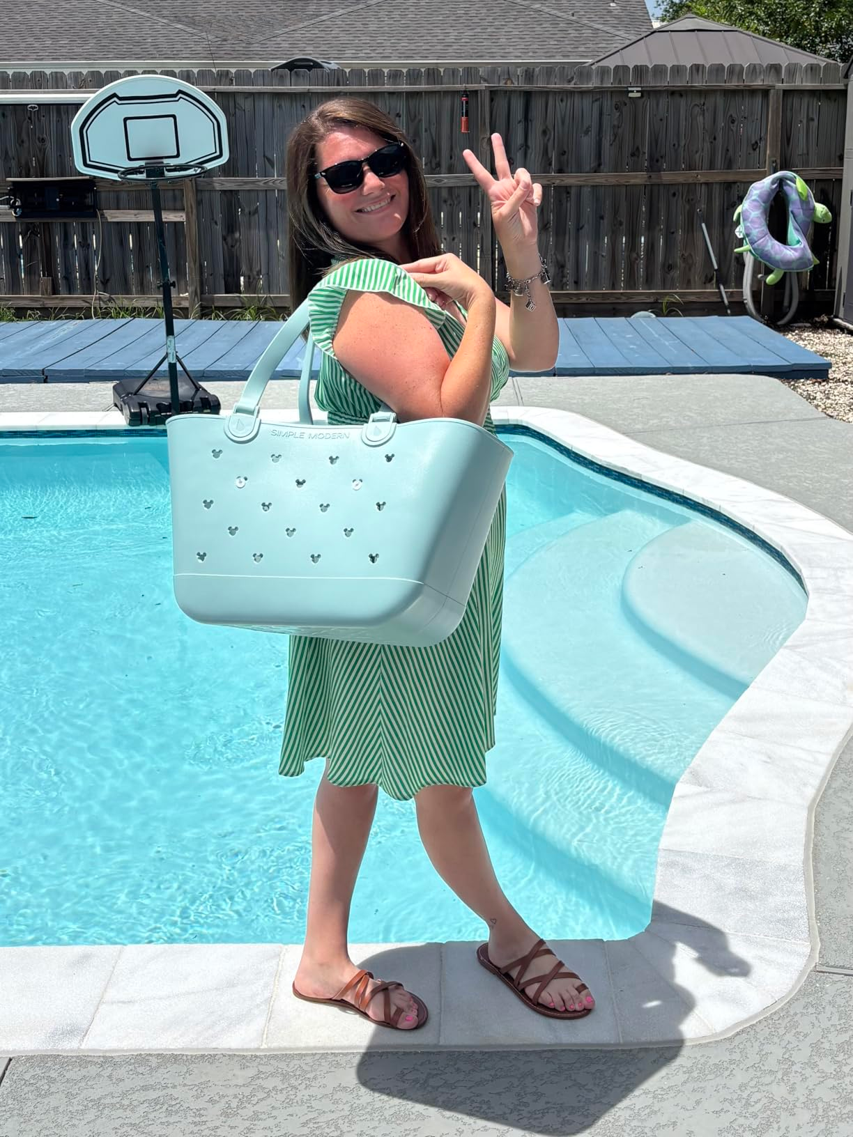 Woman by excavation  successful  a striped formal  holding a ample  tote container  and making a bid    sign