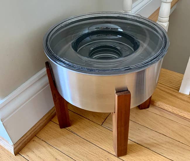 the stainless steel water bowl on a wooden stand