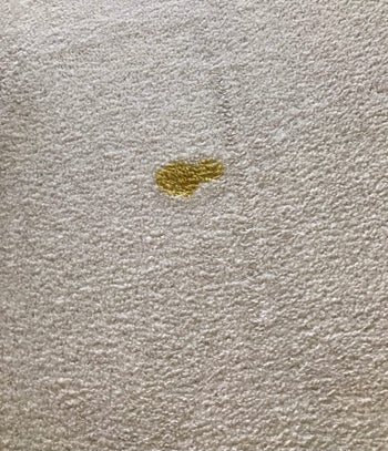 Reviewer's photo of a white carpet with a pet mess on it before using the stain remover