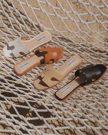 Three pairs of sandals with brand labels displayed on a textured surface