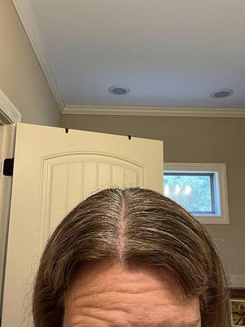 Top of a person's caput  showing disposable   grey  roots, suggesting a request   for hairsbreadth  coloring products. 