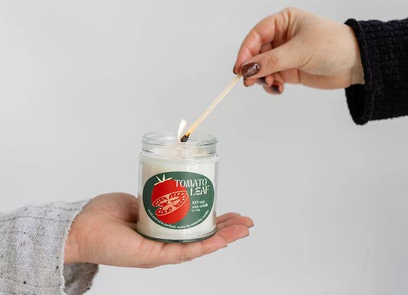A idiosyncratic   lights a candle labeled 