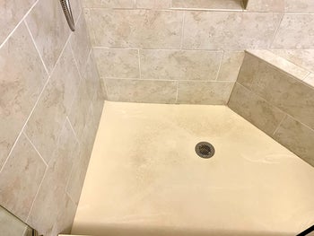 reviewer's before image of moldy, dirty shower floor and tile