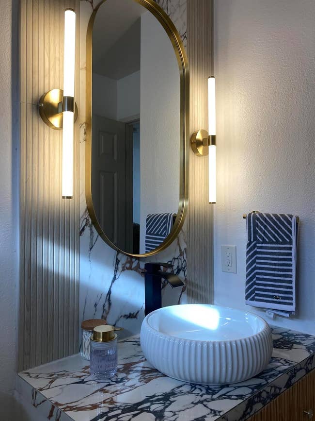 reviewer's bathroom with the gold dimmable LED lights on either side of the mirror