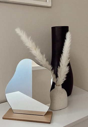 reviewer's mirror next to vases and faux flowers