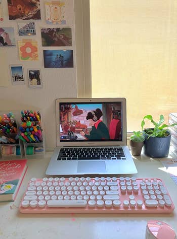 the pink keyboard and mouse set with a reviewer's laptop on a desk
