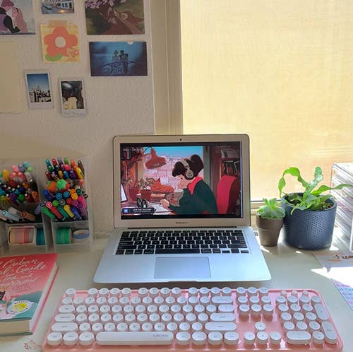 the pink keyboard and mouse set with a reviewer's laptop on a desk