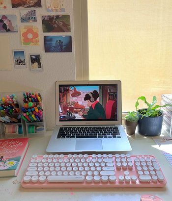 the pink keyboard and mouse set with a reviewer's laptop on a desk