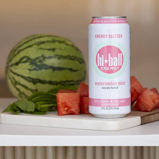 Hi-Ball Energy watermelon mint seltzer can next to a cut watermelon and mint on a counter
