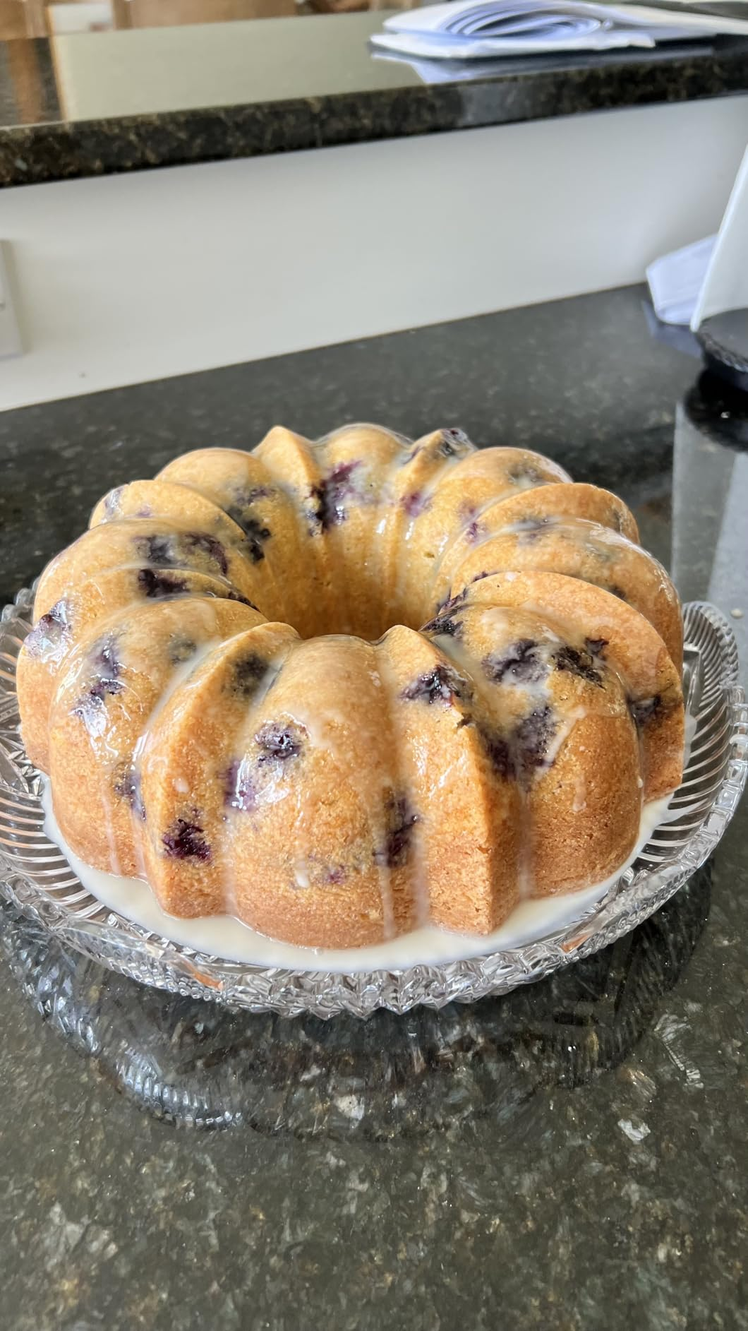 Bundt barroom   with blueberries and glaze connected  a wide   solid  plate, acceptable   connected  a acheronian  countertop