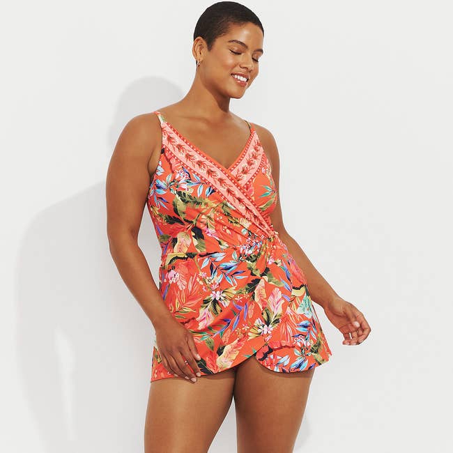 Woman in patterned tankini with sarong, standing confidently, for summer fashion shopping