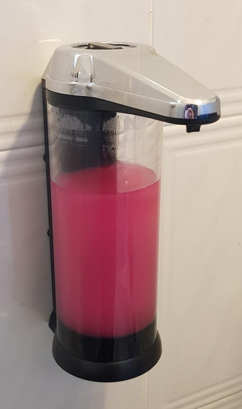 Reviewer image of the dispenser on a wall with pink soap