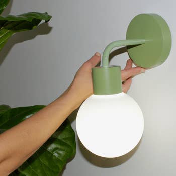 the sage green poplight mounted on a white wall