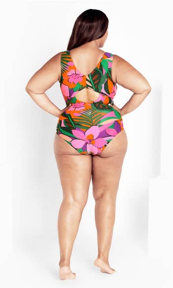 model in a floral one-piece swimsuit, back view, showcasing the design and fit