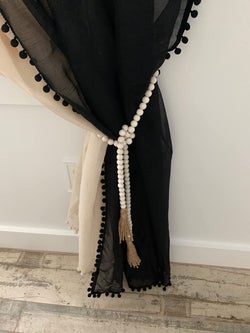 reviewer using the beds to tie back a curtain