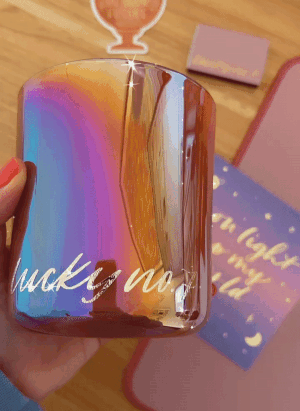 a gif of buzzfeed editor holding an iridescent candle that says 